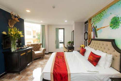 a bedroom with a large white bed with a red blanket at Belvilla Near Tan Son Nhat International Airport - Formerly Havana Hotel in Ho Chi Minh City