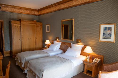 two beds in a hotel room with two lamps at Le Grand Hôtel - Domaine De Divonne in Divonne-les-Bains