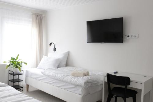 a bedroom with a bed with a desk and a television on the wall at Hotel Sport Houštka 