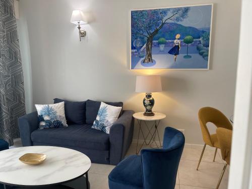 a living room with a blue couch and chairs at Hotel Le Fouquet's in Cannes
