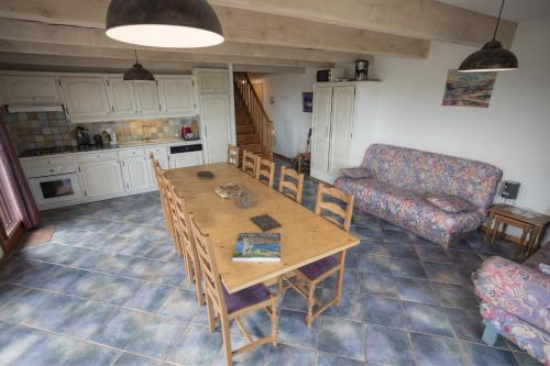 a living room with a wooden table and a couch at Gites au Cœur de la Nature, Piscine et Vue sur le Lac du Salagou in Le Puech