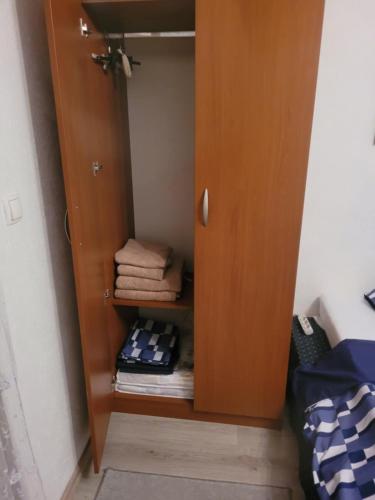 a cupboard with folded towels in a bedroom at Hiža Guesthouse in Sarajevo