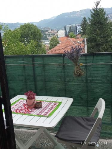 a white table and a chair on a balcony at Hiža Guesthouse in Sarajevo