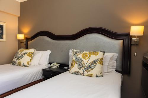 a hotel room with two beds and a telephone at Premier Hotel Cape Town in Cape Town