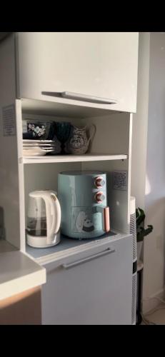 a kitchen shelf with dishes and a microwave at Condo in Batasan Hills with a Mountain view in Manila