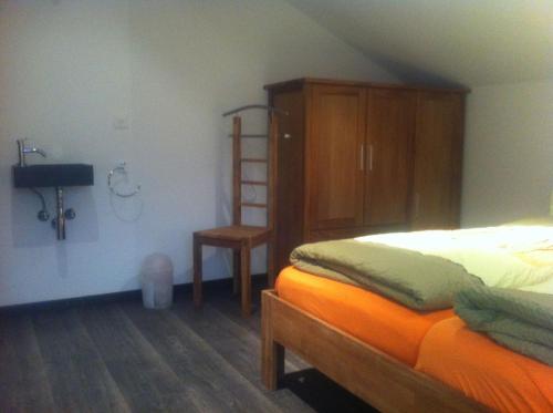 サースフェーにあるHeimathüs Saas-Feeのベッドルーム1室(ベッド1台付)、木製キャビネットが備わります。