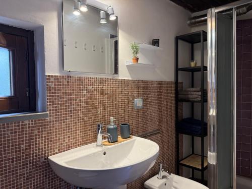 a bathroom with a sink and a mirror and a toilet at Borgoloco in Sarnano