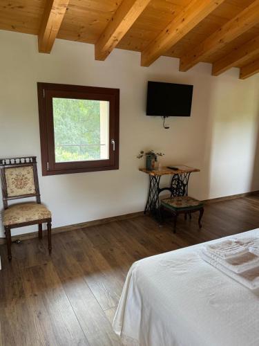 a bedroom with a bed and a table and a window at Casa dei Colli in Monzambano