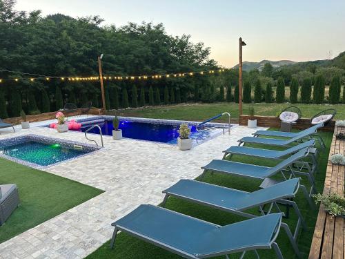 a row of blue lounge chairs next to a pool at Montana 219 in Valea Drăganului