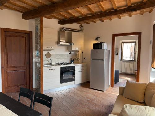 a kitchen and living room with a refrigerator and a couch at Borgoloco in Sarnano