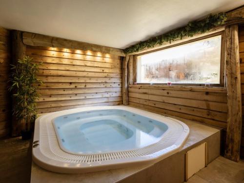 a jacuzzi tub in a wooden room with a window at Chalet Triplex 12 Pers., Luxe, Exposé Sud-Est, Proche Pistes, Animaux Acceptés - FR-1-263-156 in Valloire