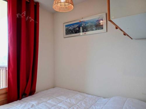 une chambre avec un lit et un rideau rouge dans l'établissement Appartement 2 pièces avec balcon, près des pistes et commerces, pour 4 personnes à Vallandry - FR-1-411-926, à Landry