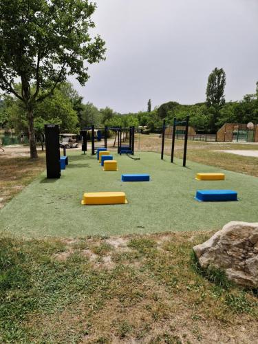 a playground with yellow and blue frisbees on the grass at Mobil home en Provence - Camping 4 étoiles- 2 chambres -4 à 6 pers-clim-terrasse-TV in Cadenet