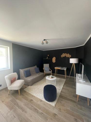 a living room with a couch and a table at Le Clos d Emilie in Saint-Marcel