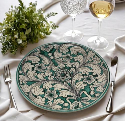a green and white plate on a table at Borbon Home luxury rooms & SPA in Palermo