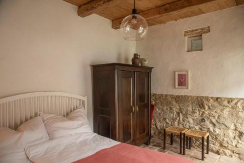 a bedroom with a bed and a wooden cabinet at dasFritsch-Historisches Weinbauernhaus im Grünen in Klein-Reinprechtsdorf