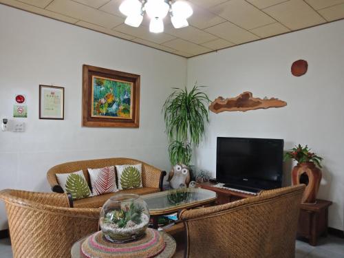 a living room with a couch and a tv at Moon Lake House Inn in Xinshe