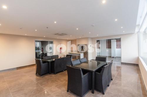 a dining room with black tables and chairs at Comfortable 2 Bed Apt In Molas Lopez in Asuncion