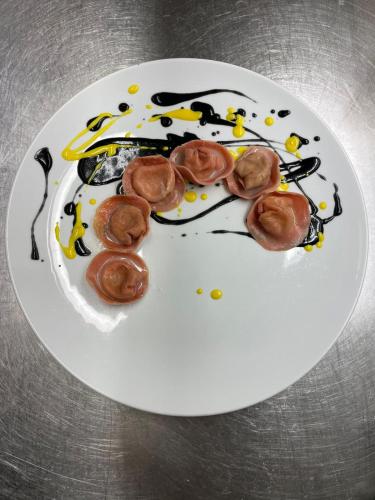 a white plate with some food on it at B&B l'Angolo di Rosina con ristorante in Novello