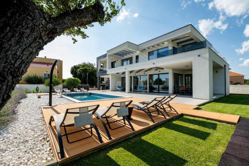 a villa with a swimming pool and lawn at Contemporary Zadar Villa 4 Bedrooms Villa Barako Prestige in Nin