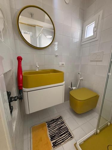 a bathroom with a yellow sink and a mirror at Tender to Carafa in Capri