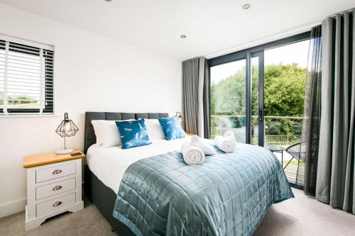 a bedroom with a bed and a large window at Robins Retreat ML55 Lower Mill Estate Cotswolds in Somerford Keynes