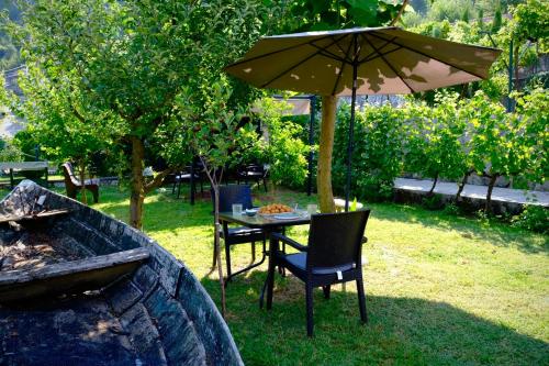 a table and chairs under an umbrella next to a grill at Country House Djurisic in Virpazar