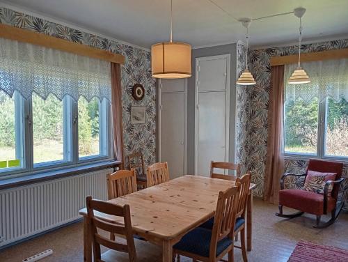 a dining room with a wooden table and chairs at sydtorp charming old house in the countryside in Rosendal