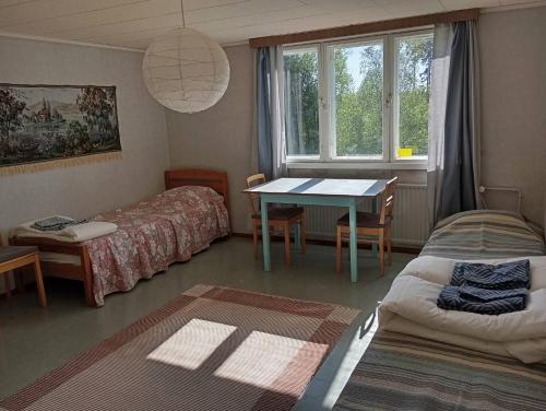 a room with a table and a bed and a table and chairs at sydtorp charming old house in the countryside in Rosendal