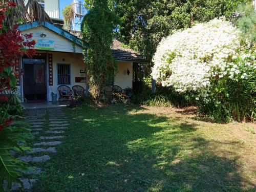 a house with a yard with white flowers in front of it at Moon Lake House Inn in Xinshe