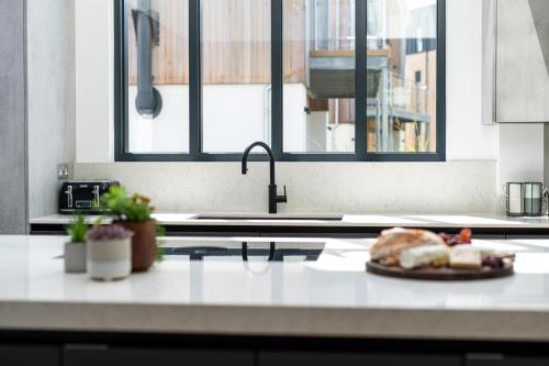 a kitchen with a sink and a plate of food on a counter at Huron House ML06 Lower Mill Estate Cotswolds in Somerford Keynes