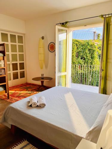 a bedroom with a bed and a window with a surfboard at Giué in Bovalino Marina