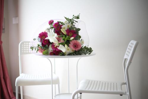 a bouquet of flowers on a table next to two chairs at My Sweet Rome Guest House in Rome