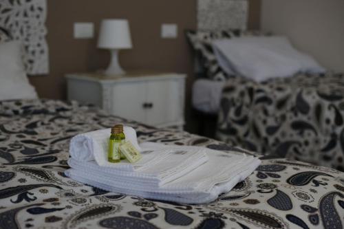 a pile of towels and a bottle on a bed at My Sweet Rome Guest House in Rome