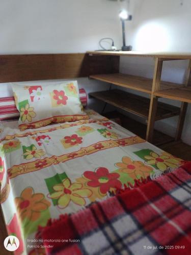a bedroom with a bed with flowers on it at Loft Ekewaka in Florianópolis