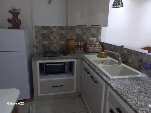 a kitchen with a sink and a stove at maison Sirène in Hammamet