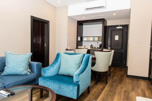 a living room with two blue chairs and a table at Premier Hotel Cape Town in Cape Town
