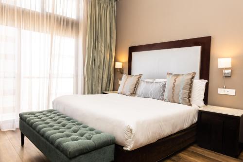 a bedroom with a large bed and a large window at Premier Hotel Cape Town in Cape Town