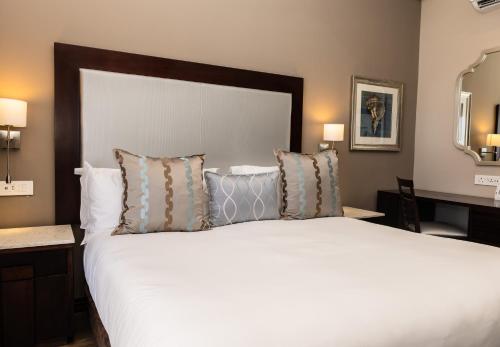 a bedroom with a large white bed with pillows at Premier Hotel Cape Town in Cape Town