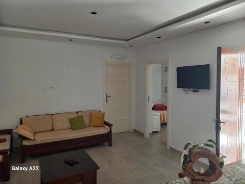 a living room with a couch and a flat screen tv at maison Sirène in Hammamet