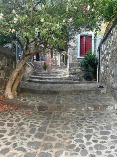 a tree in front of a brick building with stairs at Alley Home in Mithymna