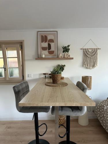 - une table en bois dans le salon avec des chaises dans l'établissement Studio au calme avec terrasse, à Rougemont