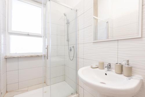 a white bathroom with a sink and a shower at Leonardo Da Vinci Guest House in Fiumicino