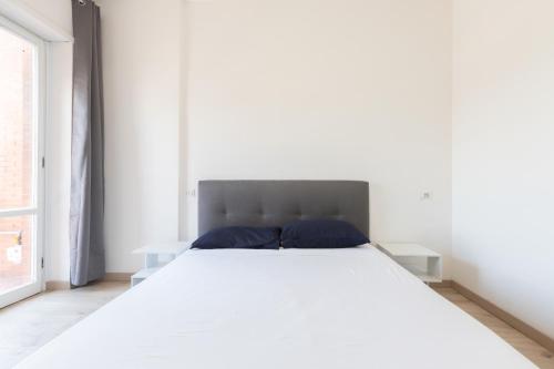 a bedroom with a large white bed with blue pillows at Leonardo Da Vinci Guest House in Fiumicino