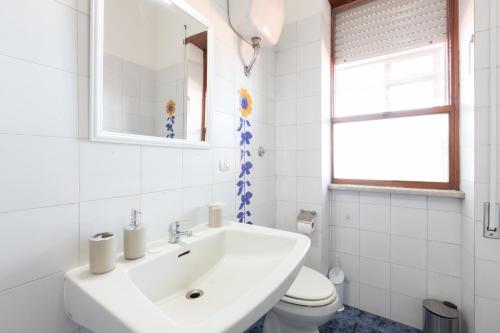 a white bathroom with a sink and a toilet at Leonardo Da Vinci Guest House in Fiumicino