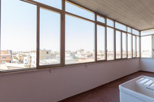 a large room with windows and a white sink at Leonardo Da Vinci Guest House in Fiumicino