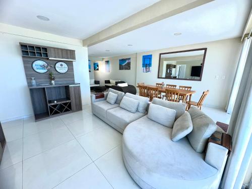 un salon avec un canapé et une salle à manger dans l'établissement Luxuosa Cobertura Vista Mar- Praia Grande, à Arraial do Cabo