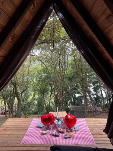 a table with two red chairs on a pink table cloth at Belas Mairiporã in Mairiporã