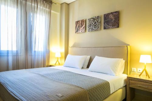 a bedroom with a bed with two pillows and a window at Deluxe Kefalonia Apartment Apartment Nectar 1 Bedroom Pool Sea View Karavomilos in Karavomylos