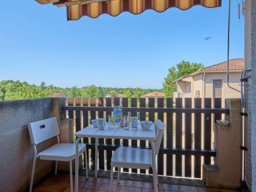 a table and two chairs on a balcony at Studio lumineux proche Lac de l'Uby avec Wi-Fi gratuit - FR-1-841-55 in Barbotan-les-Thermes